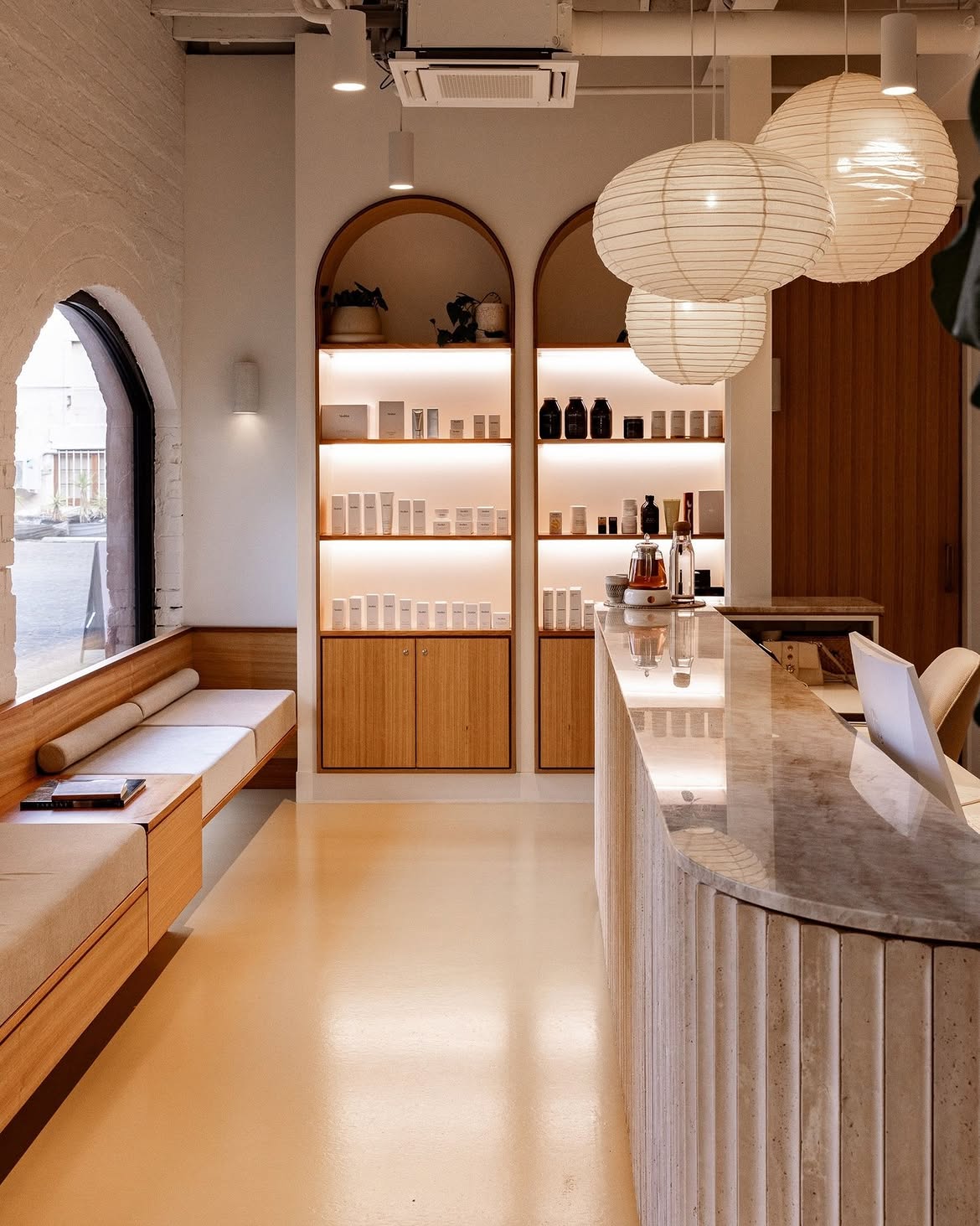 Lavada reception area with arched shelving, skincare display and travertine counter