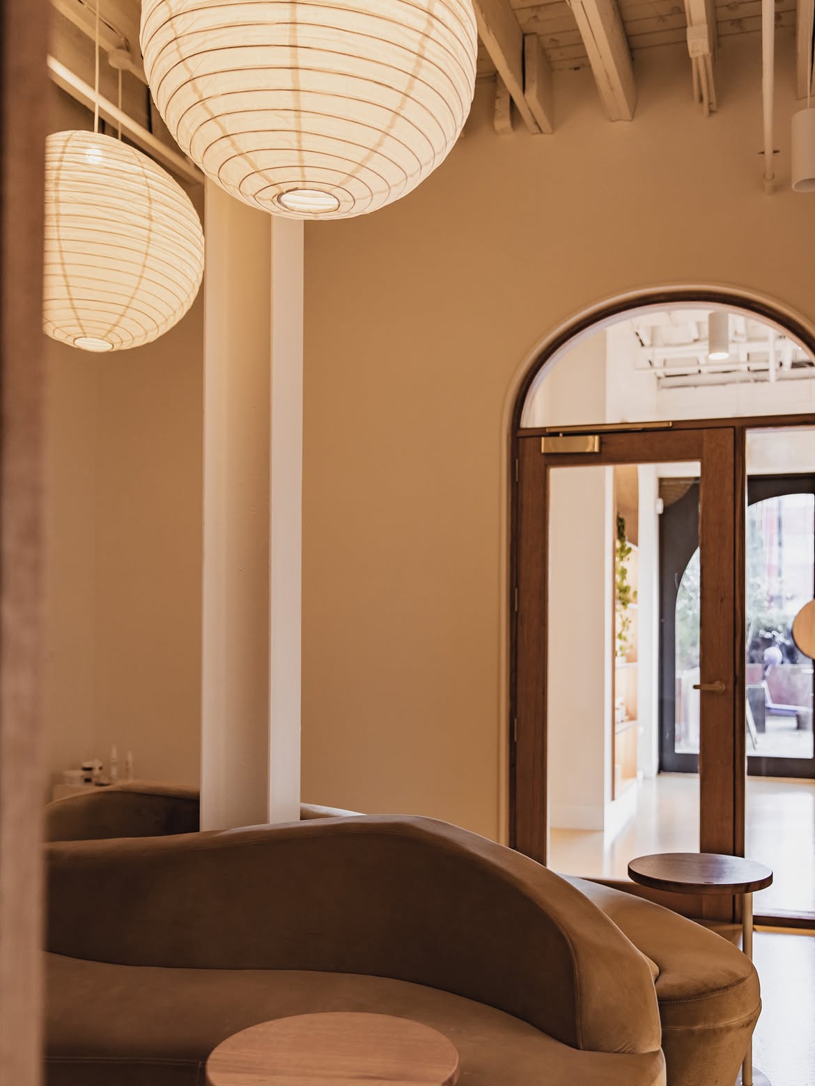 Warm-toned Lavada lounge with paper lantern pendants and curved velvet seating